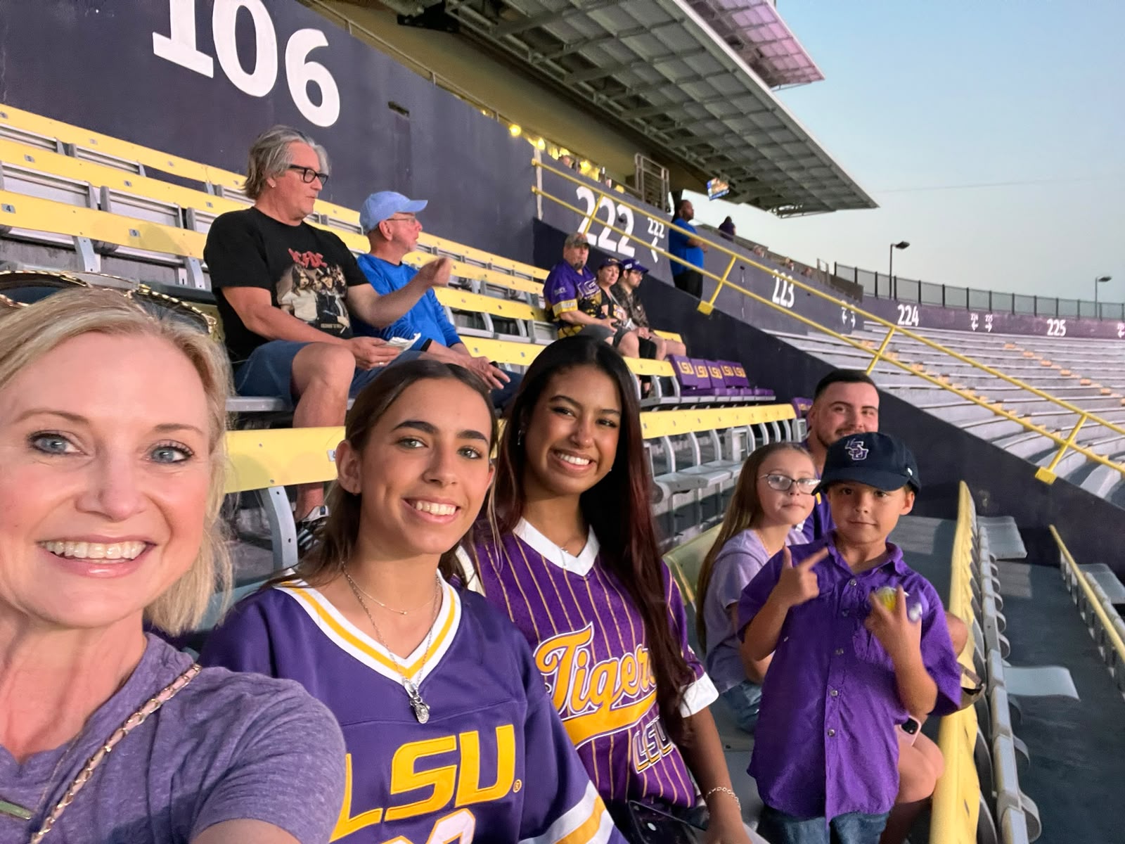 Estudiante con su familia anfitriona en un partido universitario en Estados Unidos